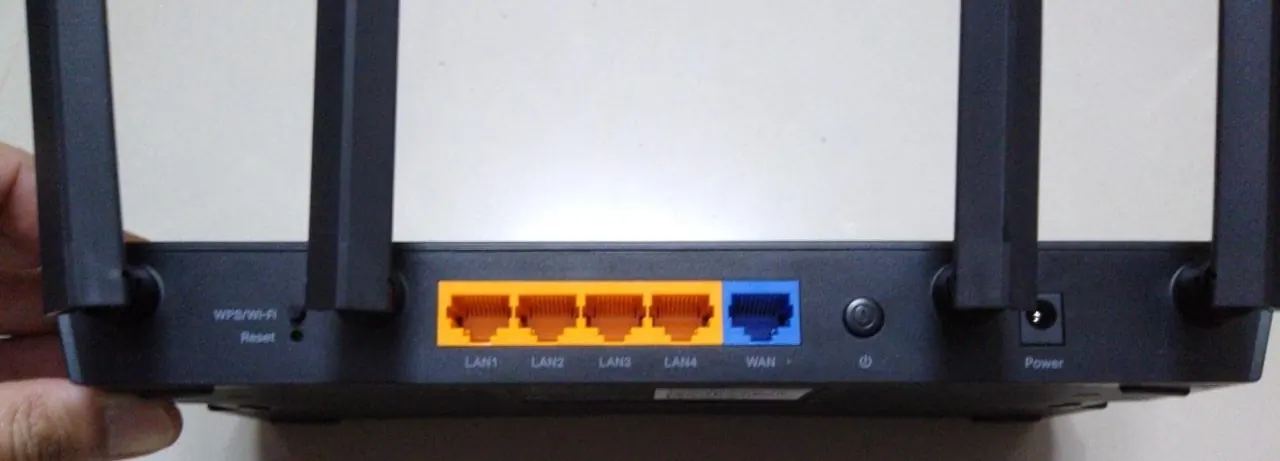 Mặt sau router Wi-Fi TP-Link với bốn cổng LAN màu cam và một cổng WAN màu xanh