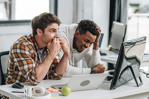 Hai lập trình viên lo lắng nhìn màn hình máy tính trong văn phòng
