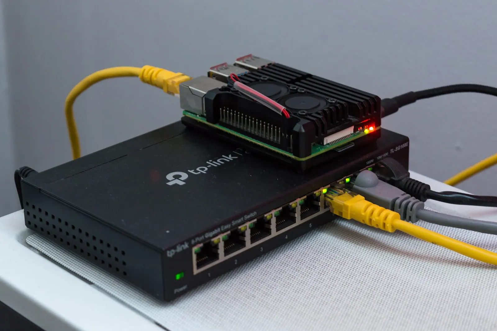 Switch TP-Link tám cổng Gigabit nối với Raspberry Pi bằng cáp mạng, đèn cổng sáng xanh