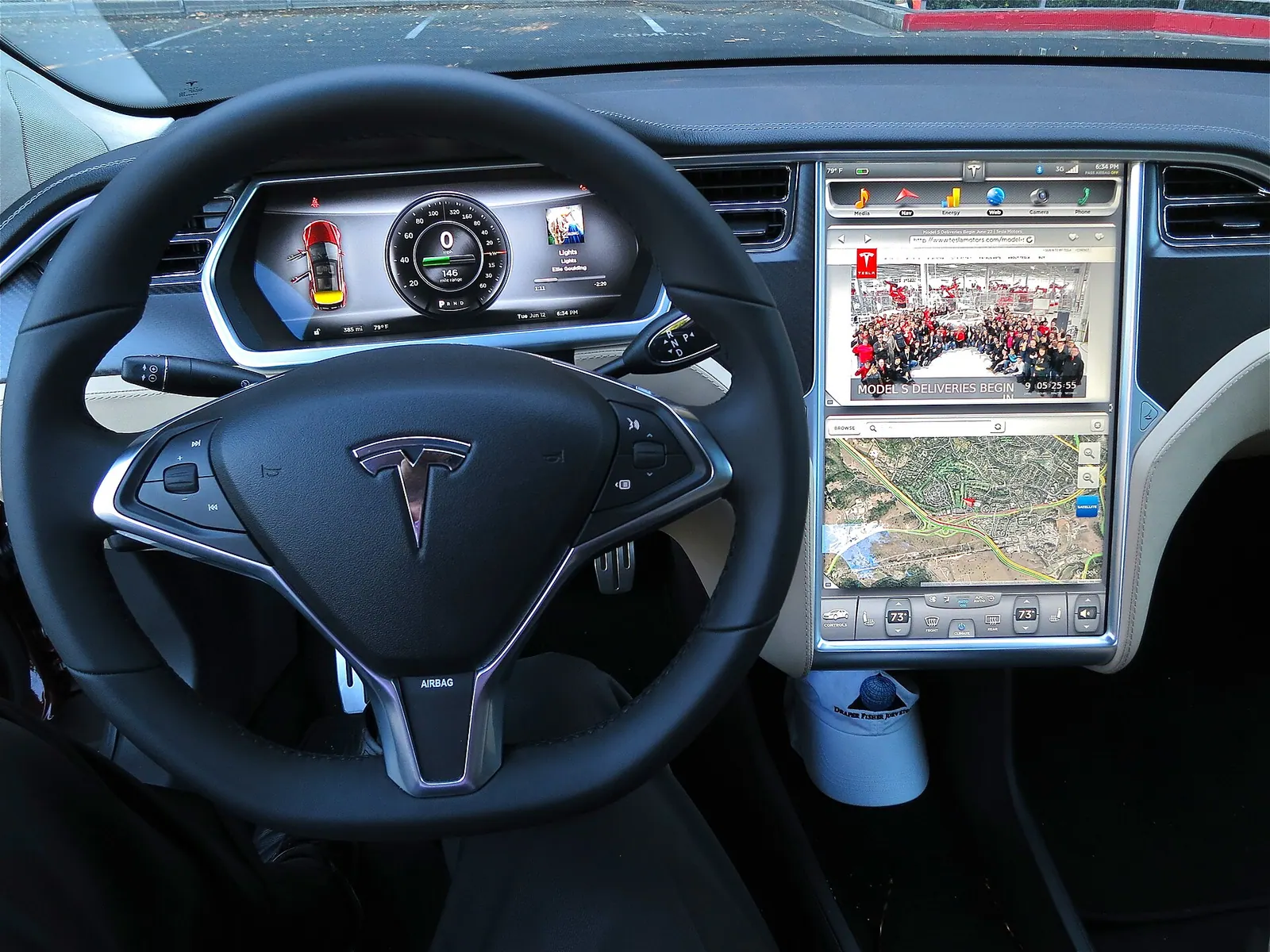Bảng đồng hồ và màn hình trung tâm của Tesla Model S, nơi người lái theo dõi phần trăm pin và quãng đường còn lại