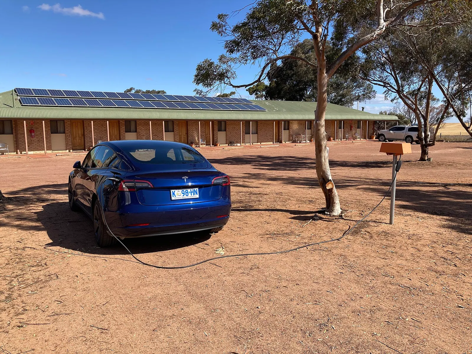 Tesla Model 3 đỗ dưới tán cây khi cắm sạc ngoài trời nắng