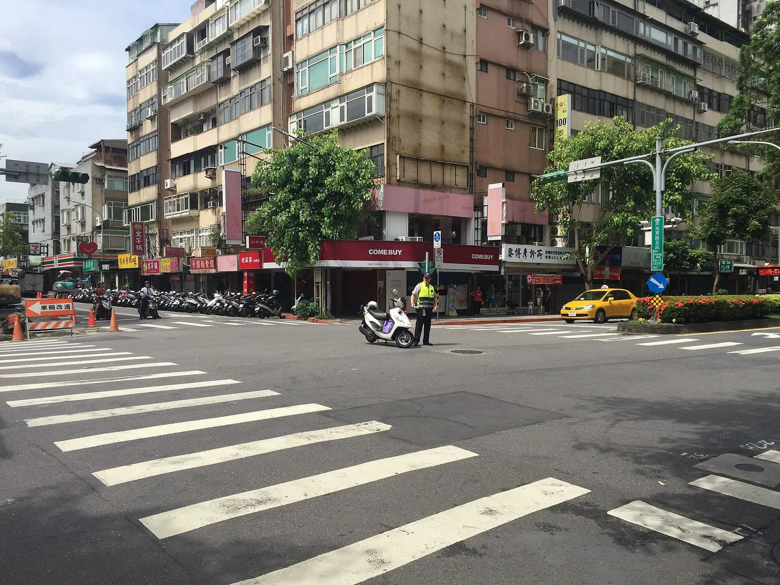 Cảnh sát giao thông đứng giữa ngã tư điều phối dòng xe máy và ô tô