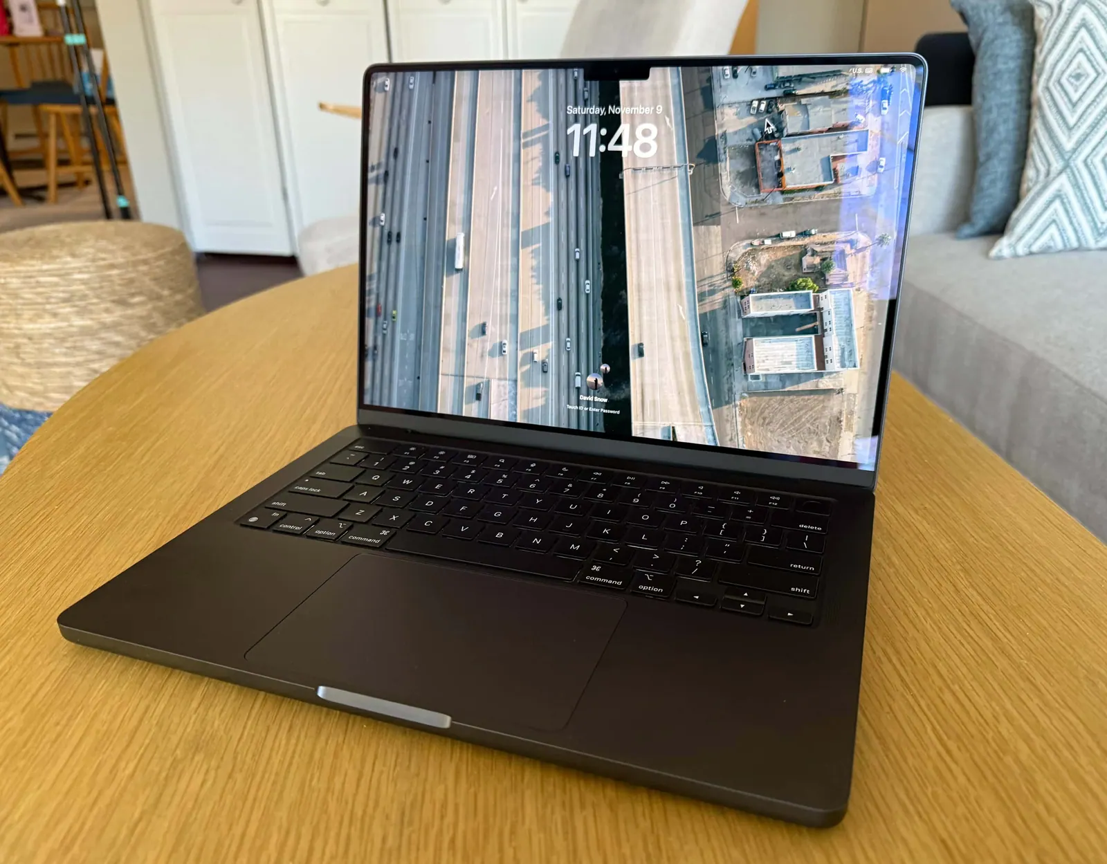 Chiếc MacBook Pro đặt trên bàn gỗ trong phòng khách