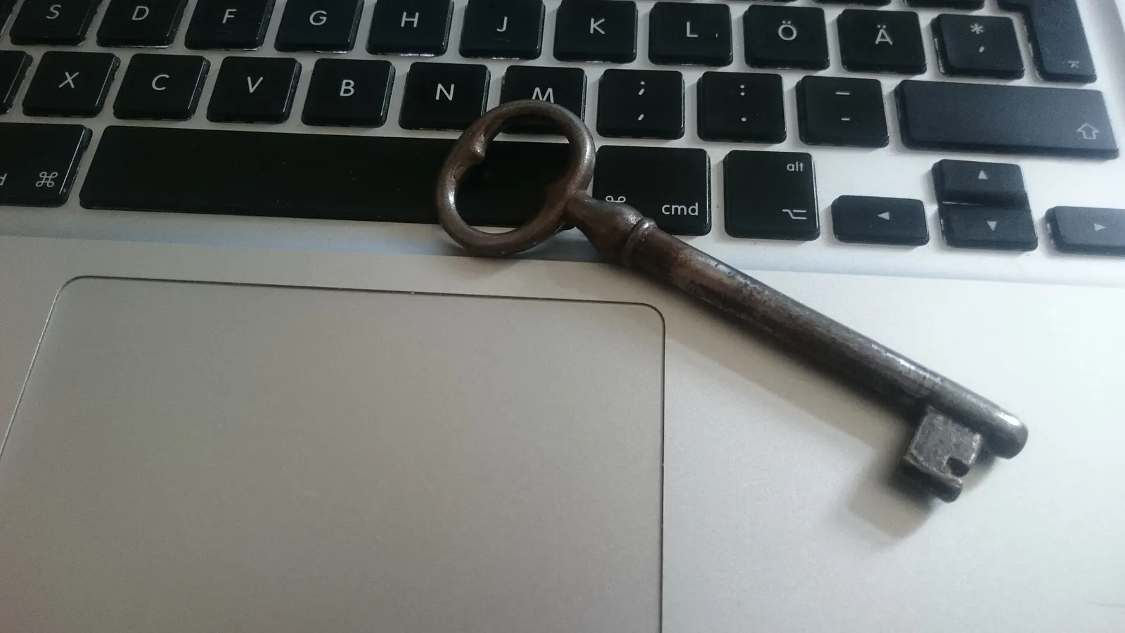 Chiếc chìa khoá cổ đặt trên bàn phím laptop, tượng trưng cho bản vá bảo mật