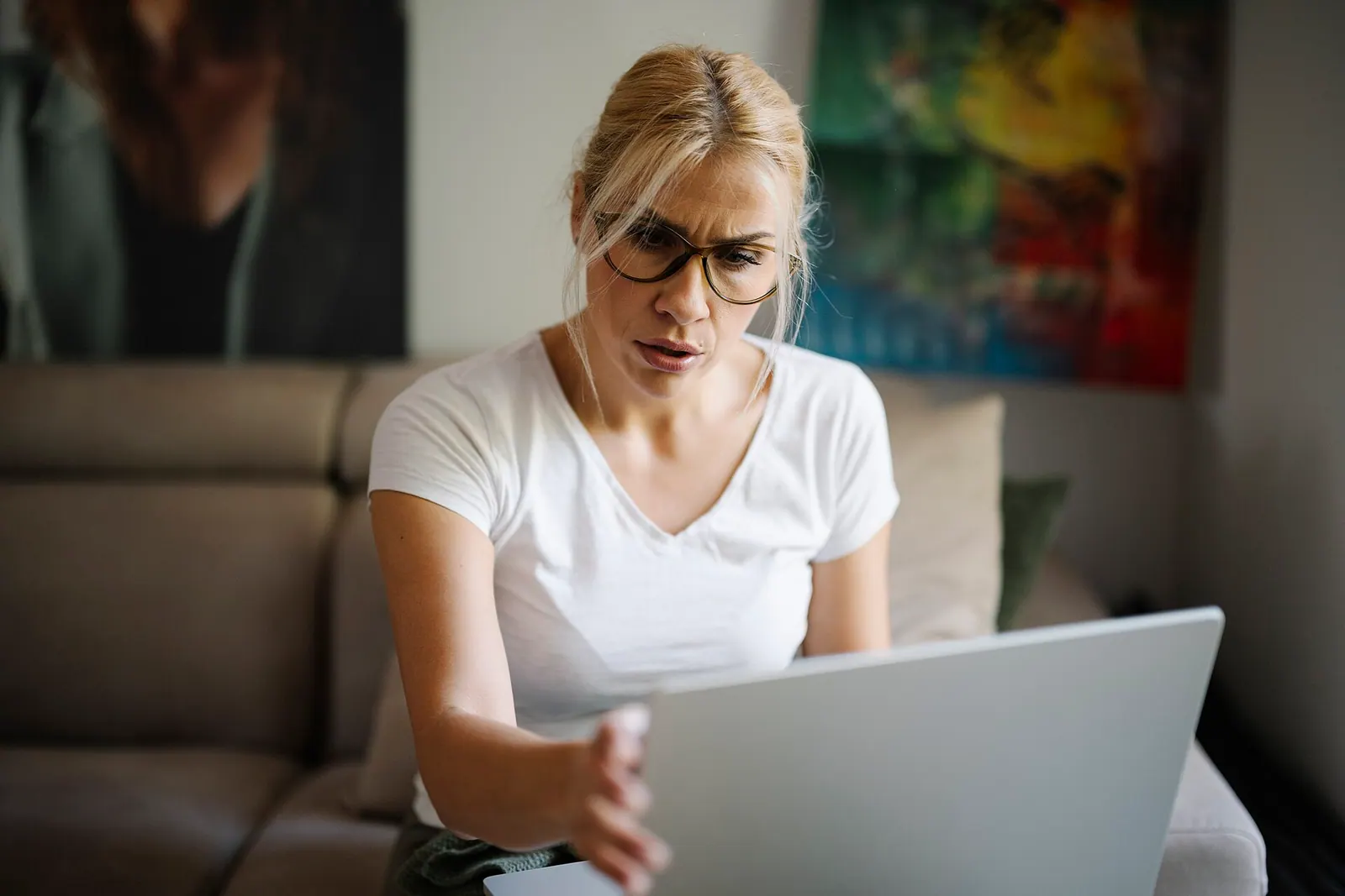 Người phụ nữ cau mày nhìn màn hình laptop khi trang web không truy cập được
